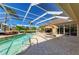 The screened pool area features comfortable lounge chairs and an umbrella for sun protection at 8315 Eagle Xing, Sarasota, FL 34241
