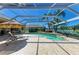 Enclosed pool and spa with sun loungers, surrounded by lush landscaping and waterfront views at 8315 Eagle Xing, Sarasota, FL 34241