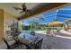 Covered patio area overlooking a pool features a dining table, lounge chairs, and a beautiful view at 8315 Eagle Xing, Sarasota, FL 34241