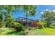 Beautiful backyard view with a screened-in pool and lush tropical landscaping at 891 Faulkwood Ct, Sarasota, FL 34232