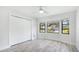 Bright bedroom features wood flooring, white walls, closet, ceiling fan, and bright windows at 891 Faulkwood Ct, Sarasota, FL 34232