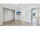 Bedroom features wood flooring, ceiling fan, television, and open doorways at 891 Faulkwood Ct, Sarasota, FL 34232