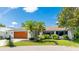 Beautiful single-story home with a wood-paneled garage door, well-maintained lawn, and vibrant foliage at 891 Faulkwood Ct, Sarasota, FL 34232
