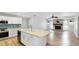 Open concept living space with kitchen island, fireplace, and wood flooring at 891 Faulkwood Ct, Sarasota, FL 34232
