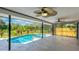 Enclosed pool area with ceiling fans and a tranquil view of the trees and waterway at 891 Faulkwood Ct, Sarasota, FL 34232