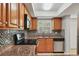 A well-lit kitchen boasts stainless steel appliances, wood cabinets, granite countertops, and tiled backsplash at 924 La Costa Cir # 4, Sarasota, FL 34237