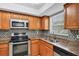 The kitchen has stainless steel appliances, wood cabinets, granite countertops, and tiled backsplash at 924 La Costa Cir # 4, Sarasota, FL 34237