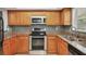 A well-equipped kitchen features stainless steel appliances, wood cabinets, granite countertops, and tiled backsplash at 924 La Costa Cir # 4, Sarasota, FL 34237