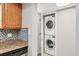 Convenient laundry setup with stacked washer and dryer and mosaic-tiled backsplash at 924 La Costa Cir # 4, Sarasota, FL 34237