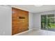 Living room with tile flooring, a wood-accent wall, and sliding glass doors to a screened-in balcony at 924 La Costa Cir # 4, Sarasota, FL 34237
