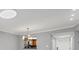 Well-lit living room featuring tile flooring, modern light fixture, and view to the entryway and kitchen at 924 La Costa Cir # 4, Sarasota, FL 34237
