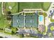 Aerial view of tennis courts, pool, and parking surrounded by lush landscaping and mature trees at 9580 High Gate Dr # 1822, Sarasota, FL 34238