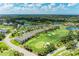 An aerial view displays the community, pool, lush landscaping, golf course, and a beautiful lake at 9580 High Gate Dr # 1822, Sarasota, FL 34238