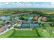 Aerial showcases tennis courts, a golf course, clubhouse, community pool, lake and meticulously maintained greenery at 9580 High Gate Dr # 1822, Sarasota, FL 34238