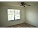 Bedroom with wood-look floors and window with blinds at 10019 Geese Trail Cir, Sun City Center, FL 33573