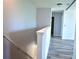 Upstairs hallway with wood-look floors and white walls at 10019 Geese Trail Cir, Sun City Center, FL 33573