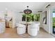 Bright dining area featuring a modern light fixture, a round table, and four white chairs at 1031 Contento St, Sarasota, FL 34242