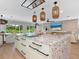 Bright, modern kitchen featuring a spacious island with cooktop and unique multicolored stone countertop at 1031 Contento St, Sarasota, FL 34242