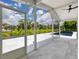 Screened patio with a view of lush greenery, blue skies, and a rectangular in-ground pool at 1031 Contento St, Sarasota, FL 34242