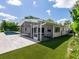 View of the backyard showcasing the pool, the screened patio, well-manicured landscaping, and manicured lawn at 1031 Contento St, Sarasota, FL 34242