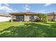 Landscaped backyard featuring a small palm tree and a screened in lanai at 11221 Sandhill Preserve Dr, Sarasota, FL 34238