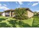 View of backyard, showing a palm tree and blooming flowers near house at 11221 Sandhill Preserve Dr, Sarasota, FL 34238