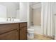 Cozy bathroom with white shower curtain and white toilet situated next to brown vanity and sink at 11221 Sandhill Preserve Dr, Sarasota, FL 34238