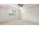 Bright, empty bedroom with neutral carpet, white walls, and a tray ceiling with ceiling fan at 11221 Sandhill Preserve Dr, Sarasota, FL 34238