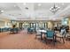 Large community room with elegant chandeliers, tables, chairs, and multiple doors at 11221 Sandhill Preserve Dr, Sarasota, FL 34238