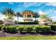 View of the community entrance sign nestled among mature, manicured landscaping at 11221 Sandhill Preserve Dr, Sarasota, FL 34238