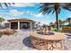 Beautiful community fire pit with stone surround, overlooking the pavilion and tropical landscaping at 11221 Sandhill Preserve Dr, Sarasota, FL 34238