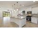 Spacious kitchen with a large granite island, white cabinets, and stainless steel appliances with an open layout at 11221 Sandhill Preserve Dr, Sarasota, FL 34238