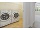 Bright laundry room features a modern washer and dryer, with a view to the next room at 11221 Sandhill Preserve Dr, Sarasota, FL 34238