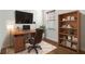 Home office features a wood desk, a leather chair, a large TV, and a hardwood bookshelf at 11221 Sandhill Preserve Dr, Sarasota, FL 34238