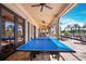 Outdoor ping pong table area with covered seating and views of the pool at 11221 Sandhill Preserve Dr, Sarasota, FL 34238