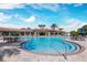 View of the community pool and surrounding area with chairs, tables and umbrellas at 11221 Sandhill Preserve Dr, Sarasota, FL 34238