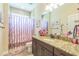Bathroom with a vanity with granite countertop, a decorative mirror, and a shower featuring a curtain at 12398 Keyridge Loop, Largo, FL 33778