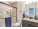 Well-lit bathroom featuring a tiled walk-in shower, and vanity with granite countertop and nautical décor at 12398 Keyridge Loop, Largo, FL 33778