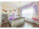 Charming bedroom featuring hardwood floors, decorative purple accents, chandelier, and ample natural light at 12398 Keyridge Loop, Largo, FL 33778