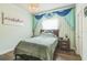 Tranquil bedroom featuring hardwood floors, a chandelier, and a decorative blue window treatment at 12398 Keyridge Loop, Largo, FL 33778