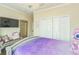 Bedroom featuring a chandelier, large mirror, bench and purple bedding, offering elegance and comfort at 12398 Keyridge Loop, Largo, FL 33778