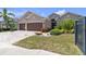 Charming single-story home featuring a three-car garage, mature landscaping, and a brick-paved driveway at 12398 Keyridge Loop, Largo, FL 33778