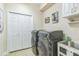 Well-lit laundry room with new front load washer/dryer, upper cabinets, and tiled flooring at 12398 Keyridge Loop, Largo, FL 33778