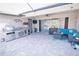 Covered outdoor patio showcasing kitchen, seating, outdoor television and tiled flooring at 12398 Keyridge Loop, Largo, FL 33778
