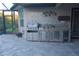 View of the outdoor kitchen featuring a stainless steel grill and sink, set against the patio at 12398 Keyridge Loop, Largo, FL 33778