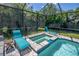 The screen-enclosed pool area has an in-ground pool and spa with several lounge chairs at 12398 Keyridge Loop, Largo, FL 33778