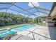 Backyard pool and spa area featuring a covered patio, outdoor grill and lush landscaping at 12398 Keyridge Loop, Largo, FL 33778