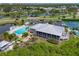 Aerial view of the pool, tennis court, clubhouse, and surrounding lush landscaping at 1319 Perico Point Cir, Bradenton, FL 34209