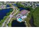 Aerial view of tennis courts, clubhouse, pool, and waterways surrounded by lush greenery at 1319 Perico Point Cir, Bradenton, FL 34209