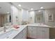 Bathroom with double sinks, bright lighting, granite countertops, and decorative accents at 1319 Perico Point Cir, Bradenton, FL 34209